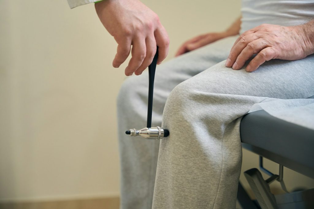 Doctor checking nervous system of elderly patient