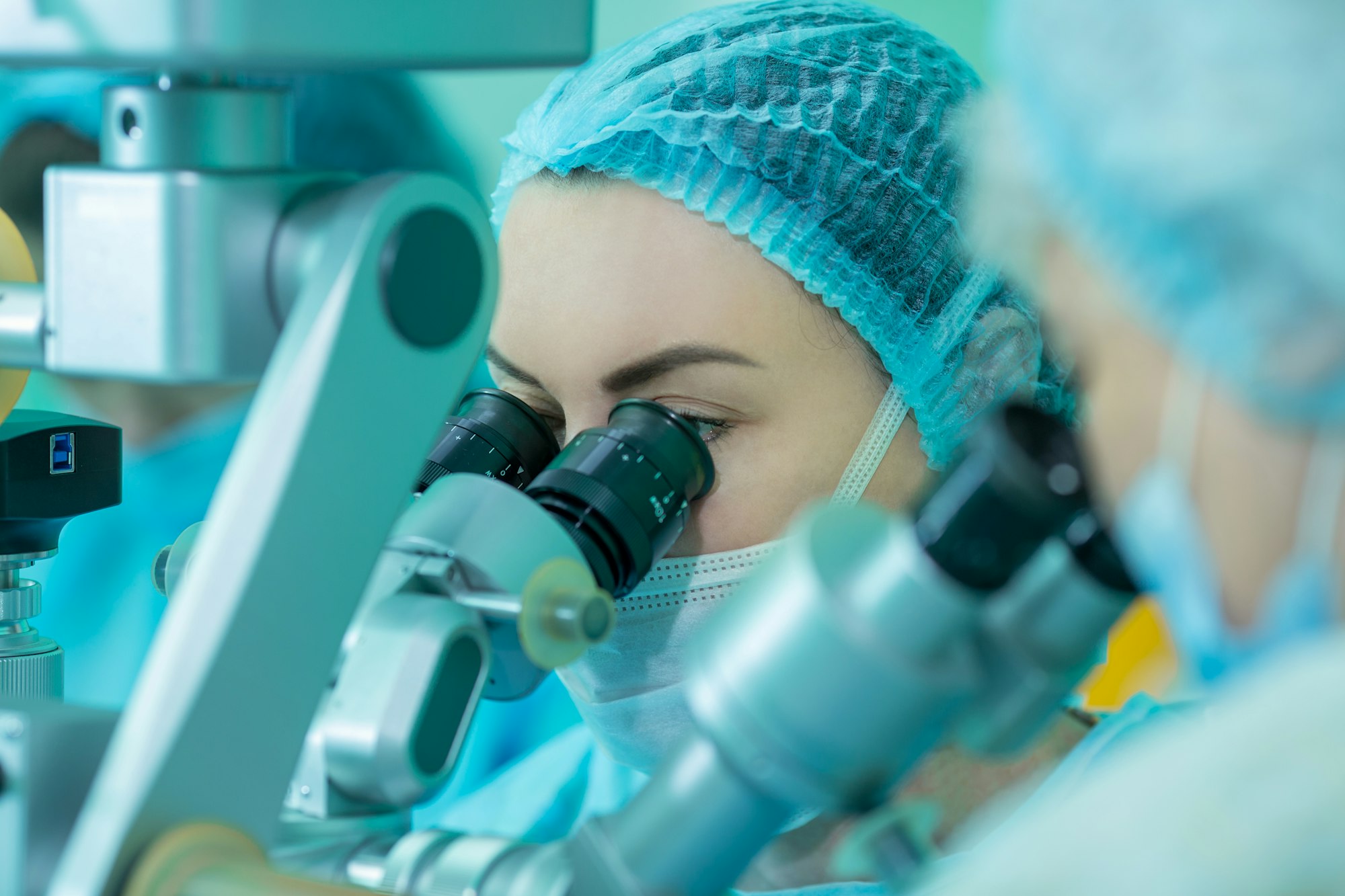 female doctors looking into a microscope. the concept of eye surgery