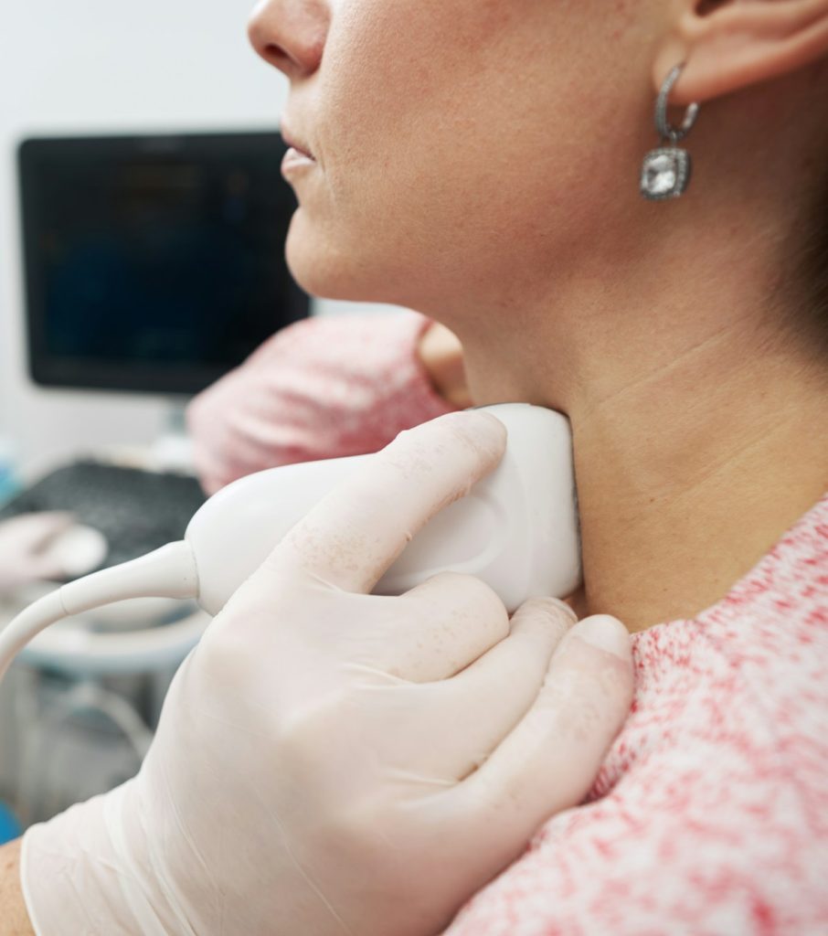 Young woman undergoing an examination of thyroid gland at the endocrinolodist